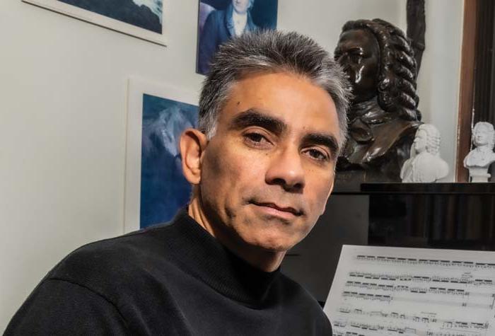 Ralf Gawlick seated at the piano in his office